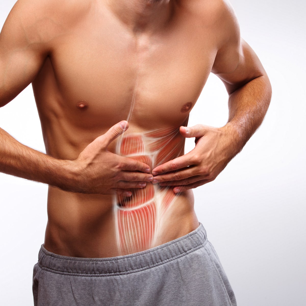 © Ortho Health Institut in München Ein Mann ohne Hemd in grauen Jogginghosen hält seinen Unterbauch mit beiden Händen. Ein überlagertes Diagramm zeigt die darunter liegenden Bauchmuskeln und hebt den geraden Bauchmuskel hervor. Das Bild vom Ortho Health Institut in München konzentriert sich auf die Anatomie und Positionierung der Bauchmuskeln.